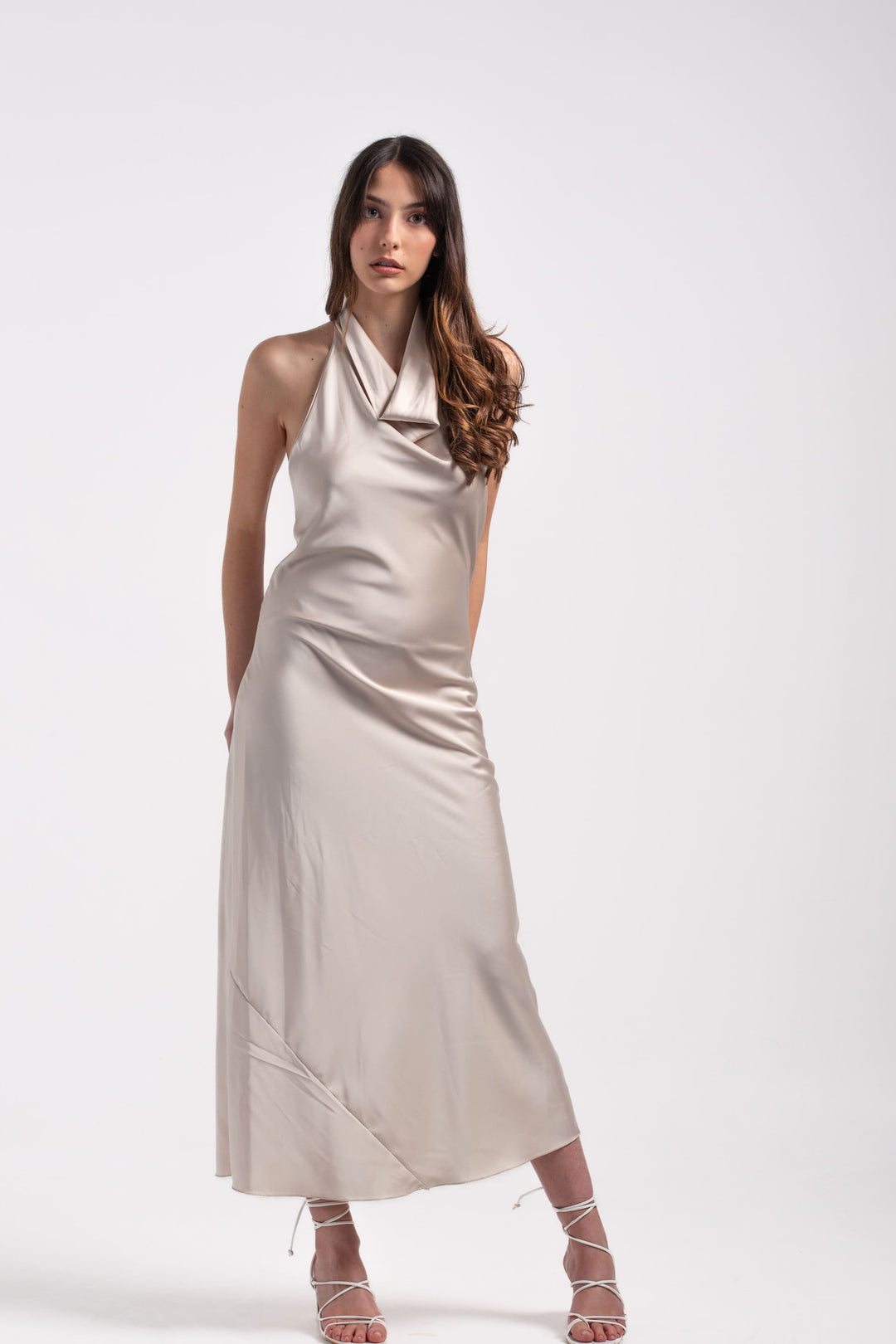 Abito lungo donna colore perla in raso satinato con scollo halter drappeggiato e linea fluida.
